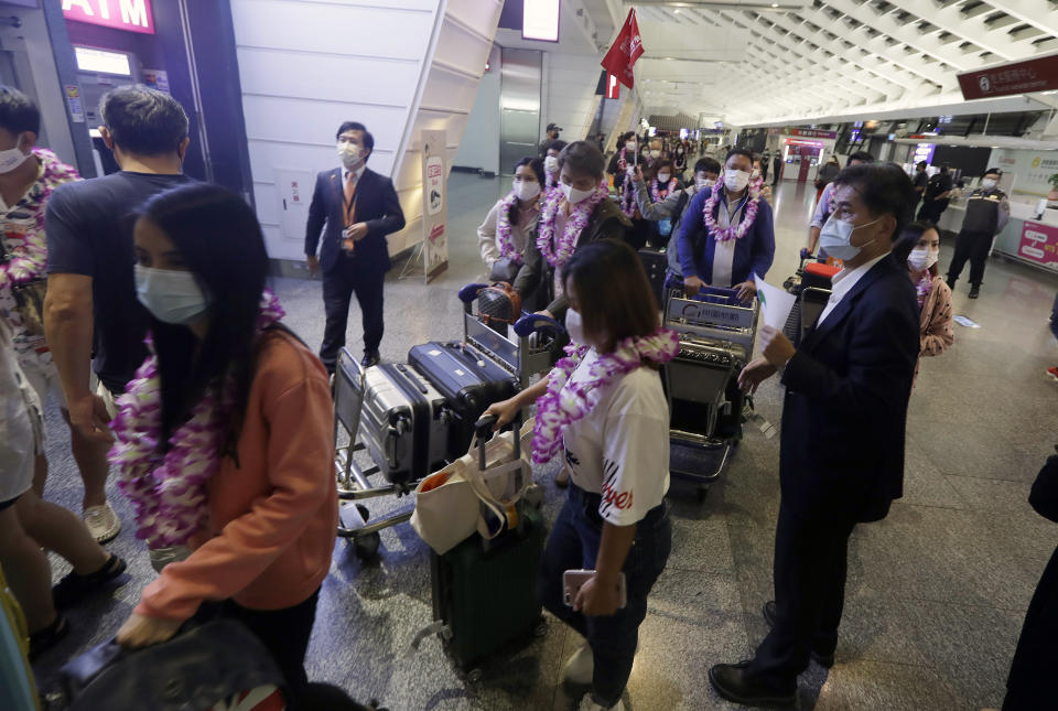 First group of foreign travelers arrive at Taoyuan International Airport in Taoyuan, Northern Taiwan, Thursday, Oct. 13, 2022. Taiwan announced that it will end mandatory COVID-19 quarantines for people arriving from overseas beginning Oct. 13. The Central Epidemic Command Center announced that the previous weeklong requirement will be replaced with a seven-day self-monitoring period. (AP Photo/Chiang Ying-ying)
