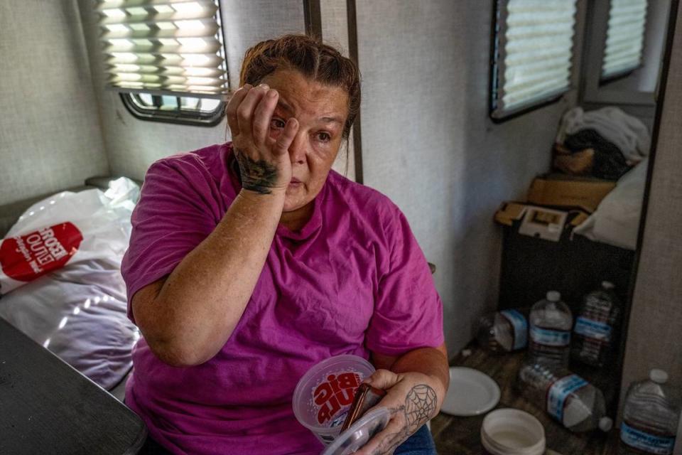 Tamitha Myler, 55, wipes tears in her camping trailer in North Sacramento’s Camp Resolution in August while talking about how long she has been waiting on housing. “I just get so frustrated and get tired of it after a while.” said Myler.