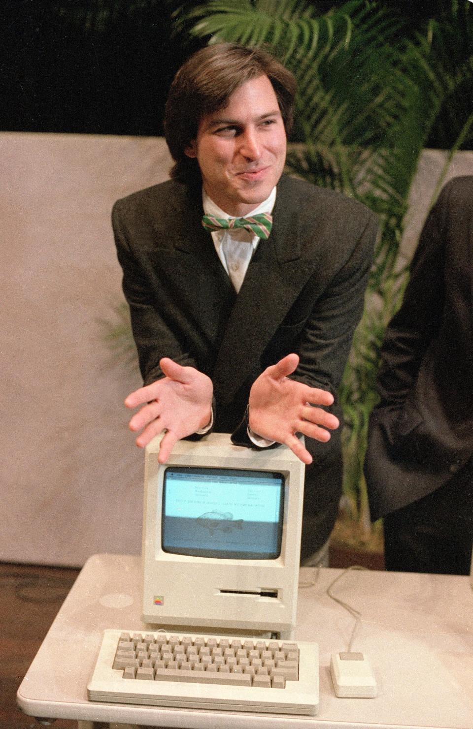 In this Jan. 24, 1984, file photo, Steve Jobs, chairman of the board of Apple Computer, leans on the new "Macintosh" personal computer following a shareholder's meeting in Cupertino, Calif.