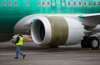 An employee walks past a Boeing 737 Max aircraft at Boeing's 737 Max production facility in Renton