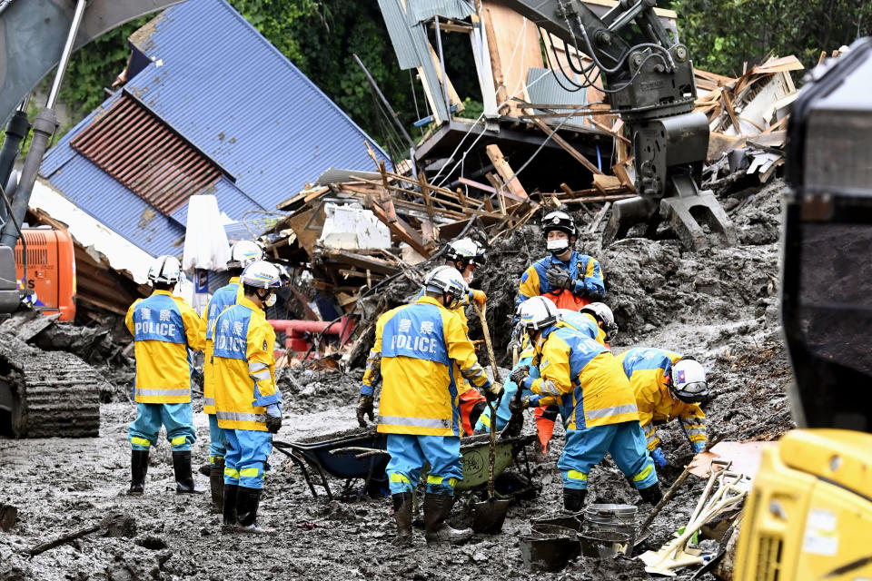 Rescuers work to clear mud at the site of a mudslide in Atami, southwest of Tokyo Wednesday, July 7, 2021. Workers are searching carefully inside homes that were destroyed and filled with mud in Saturday's disaster. (Kyodo News via AP)