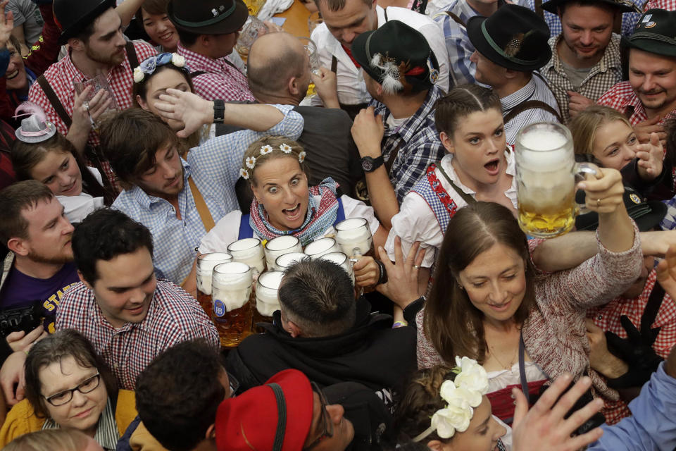 A waitress is surrounded by visitors at Oktoberfest