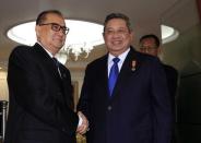 North Korean Foreign Minister Ri Su Yong (L) shakes hands with Indonesian President Susilo Bambang Yudhoyono at the presidential palace in Jakarta, August 13, 2014. REUTERS/Beawiharta