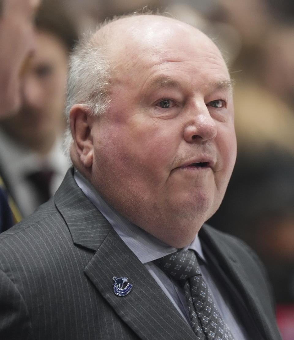 Vancouver Canucks head coach Bruce Boudreau stands behind the bench before the team's NHL hockey game against the Edmonton Oilers on Saturday, Jan. 21, 2023, in Vancouver, British Columbia. (Darryl Dyck/The Canadian Press via AP)