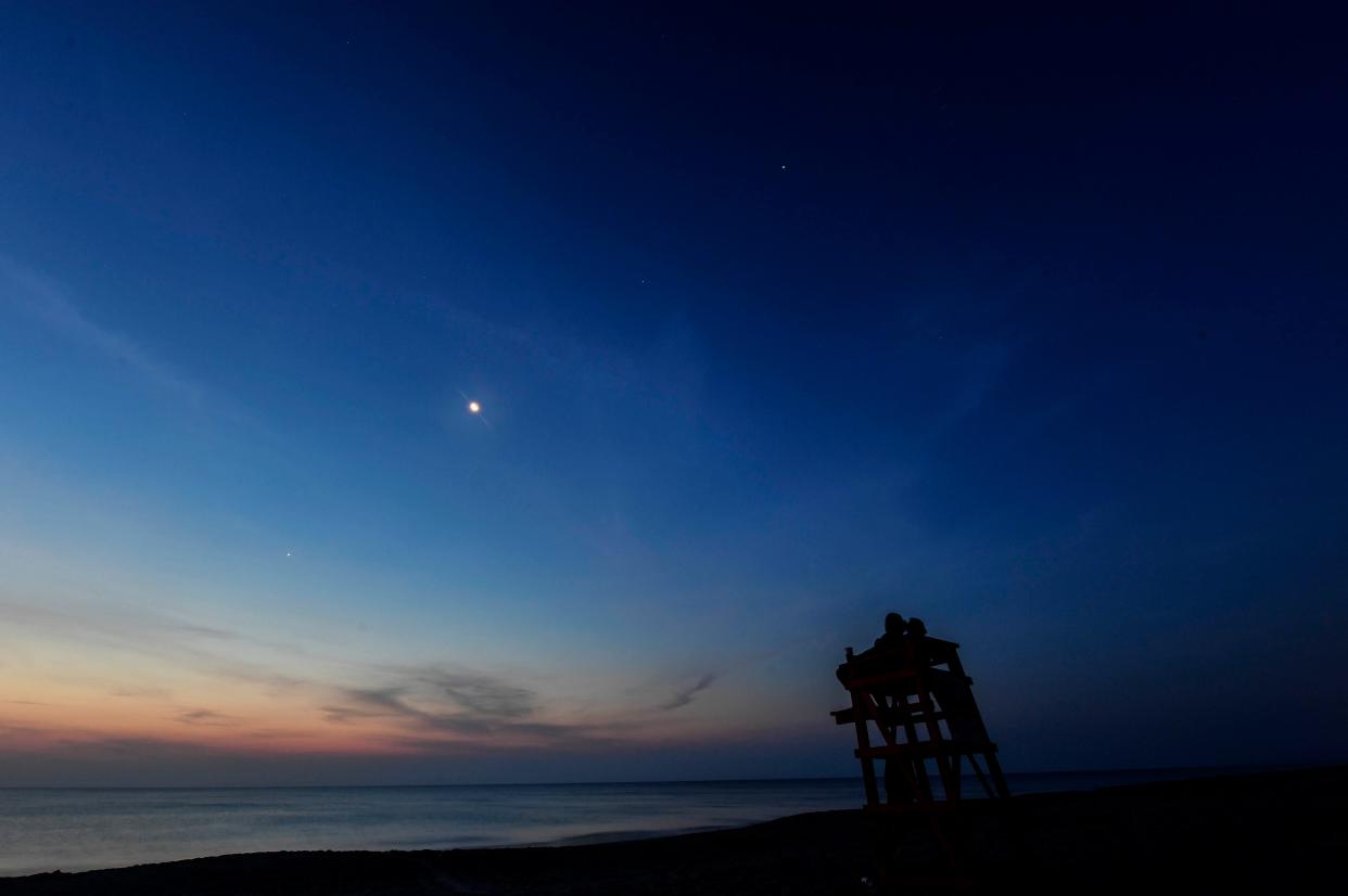 June 24, 2022:  Early risers watch as the crescent Moon joins the planets Mercury, Venus, Uranus, Mars, and Jupiter as they align in the skies over Melbourne Beach Friday morning.