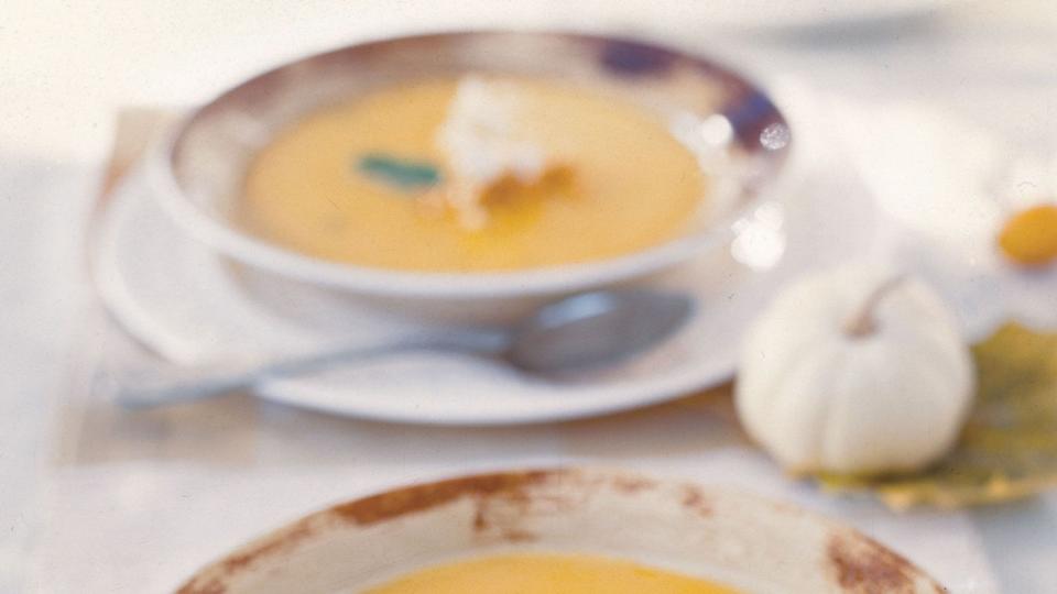 a bowl of butternut squash soup with a spoon