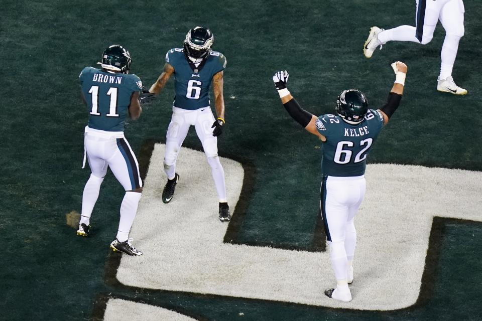 Philadelphia Eagles wide receiver DeVonta Smith (6) celebrates his touchdown catch with wide receiver A.J. Brown (11) and center Jason Kelce (62) during the first half of an NFL divisional round playoff football game against the New York Giants, Saturday, Jan. 21, 2023, in Philadelphia. (AP Photo/Chris Szagola)