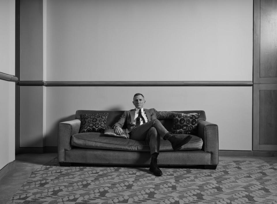 A black and white image of Daniel Craig sprawled on a couch.