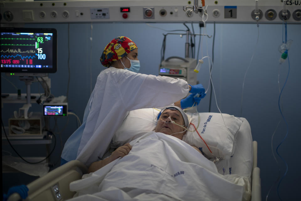 A member of the medical staff makes preparations for Francisco España, 60, to be taken out by the sea, at the "Hospital del Mar" in Barcelona, Spain, Friday, Sept. 4, 2020. A hospital in Barcelona is studying how short trips to the beach may help COVID-19 patients recover from long and traumatic intensive hospital care. The study is part of a program to “humanize” ICUs. Since re-starting it in early June, the researchers have anecdotally noticed that even ten minutes in front of the blue sea waters can improve a patient’s emotional attitude. (AP Photo/Emilio Morenatti)