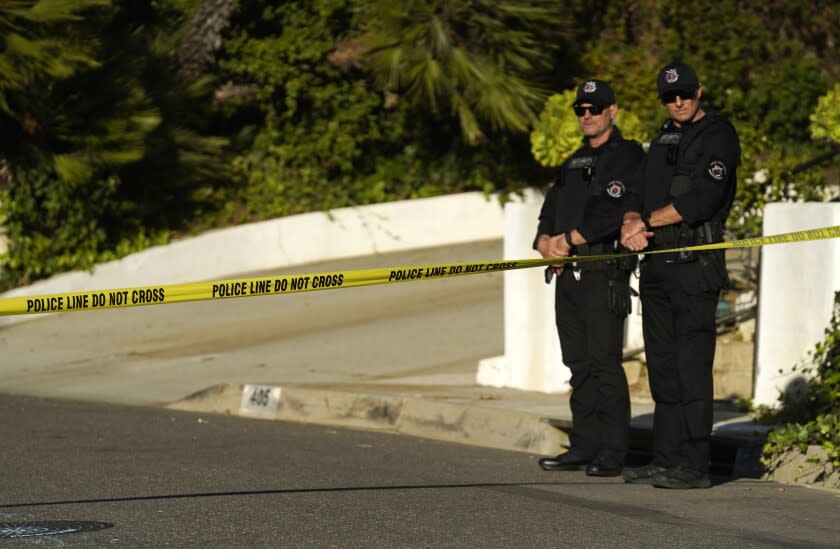 Security guards patrol behind police tape set up at the intersection of Maytor Place and Barrie Drive in the Trousdale Estates section of Beverly Hills, Calif., Wednesday, Dec. 1, 2021. Jacqueline Avant, the wife of music legend Clarence Avant, was fatally shot in the neighborhood early Wednesday. (AP Photo/Chris Pizzello)