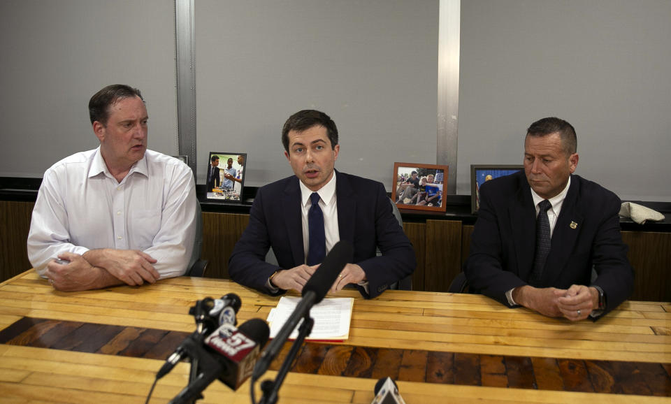 South Bend Mayor Pete Buttigieg, center, speaks during a news conference, Sunday, June 16, 2019, in South Bend, Ind., as South Bend Common Council President Tim Scott, left, and South Bend Police Chief Scott Ruszkowski, listen. Democratic presidential candidate Buttigieg changed his campaign schedule to return to South Bend for the late night news conference, after authorities say a man died after a shooting involving a police officer. (Santiago Flores/South Bend Tribune via AP)