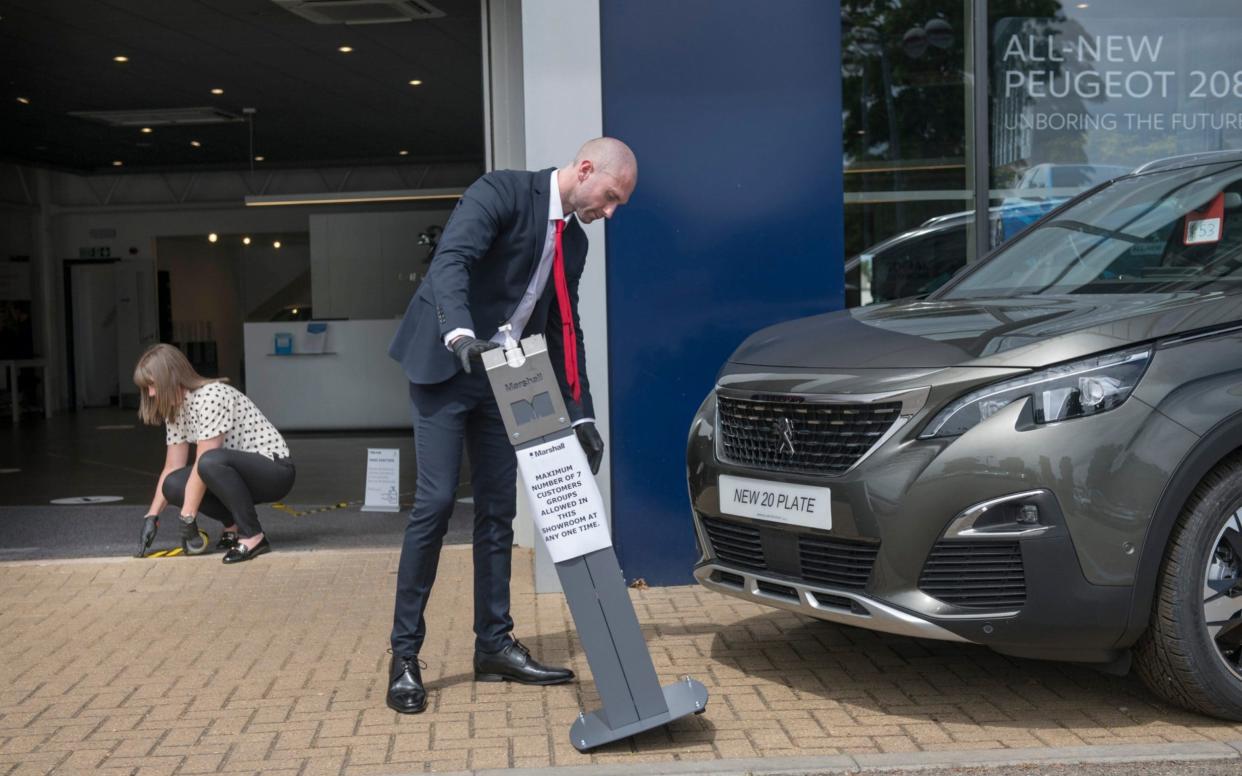 Sales Manager Anthoney Hudson and colleague Sarah Angell prepare their Peugot Car showroom for opening next week