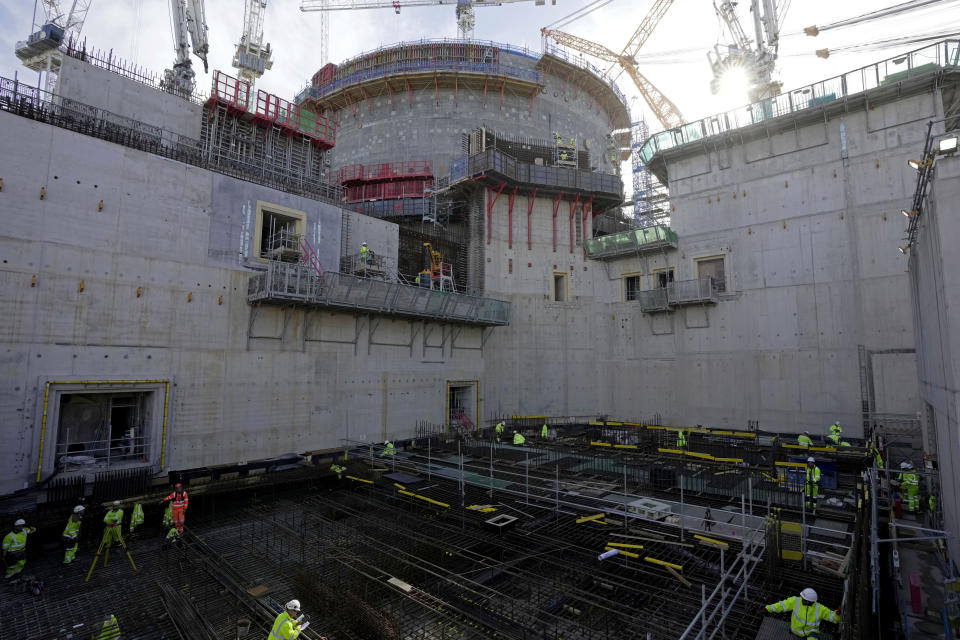 Workers work at the construction site of Hinkley Point C nuclear power station in Somerset, England, Tuesday, Oct. 11, 2022. Some experts believe the future of large nuclear plants, particularly in Europe, will hinge in part on the success of Hinkley. (AP Photo/Kin Cheung)