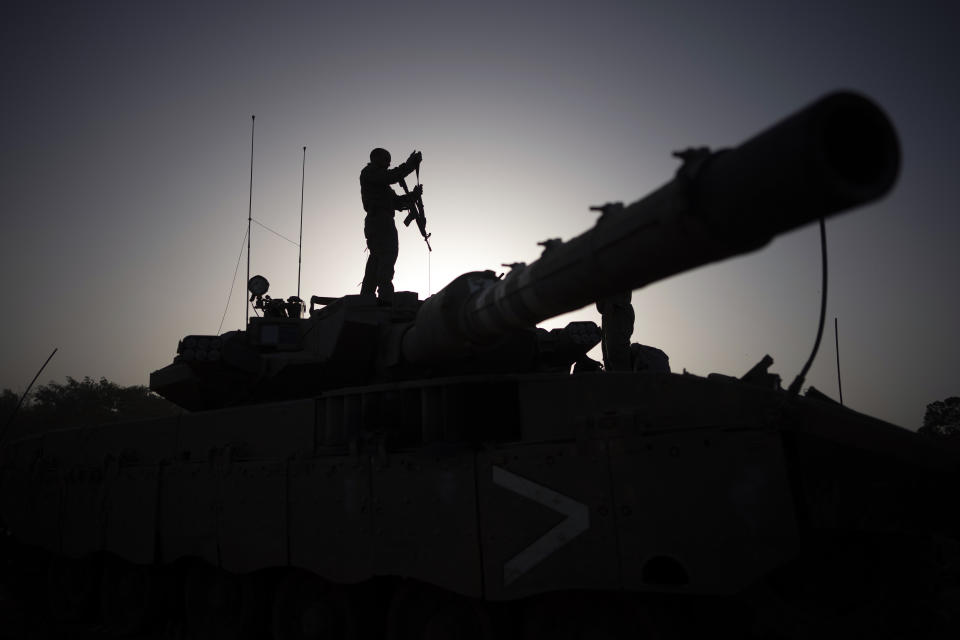 A soldier who just arrived from Gaza stands on top of a tank at an army staging area in southern Israel, Sunday, Nov. 26, 2023. (AP Photo/Victor R. Caivano)