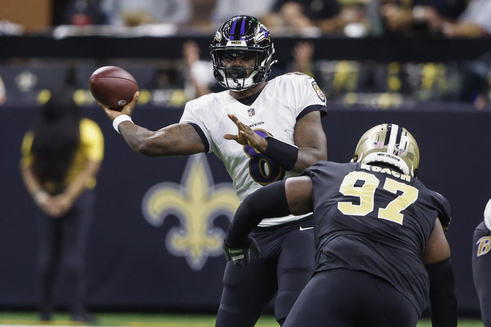 Baltimore Ravens quarterback Lamar Jackson (8) passes under pressure from New Orleans Saints defensive end Malcolm Roach (97) in the second half of an NFL football game in New Orleans, Monday, Nov. 7, 2022. (AP Photo/Butch Dill)