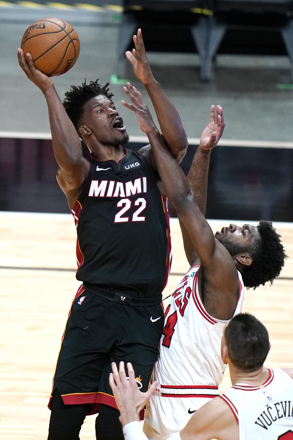 Miami Heat forward Jimmy Butler (22) shoots as Chicago Bulls forward Patrick Williams defends during the first half of an NBA basketball game, Monday, April 26, 2021, in Miami. (AP Photo/Lynne Sladky)