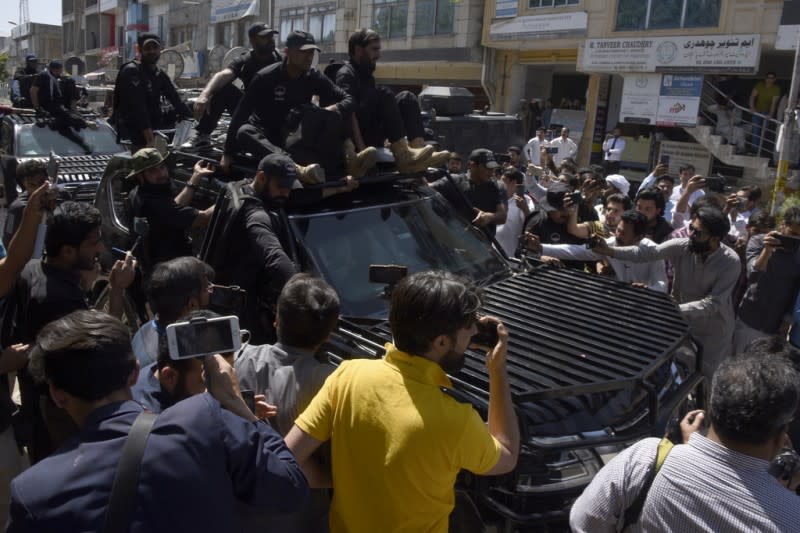 2023年5月9日，載送巴基斯坦前總理伊姆蘭·汗恩的車輛駛出法院時被大批民眾包圍，保安則試圖為其開道。（美聯社） 