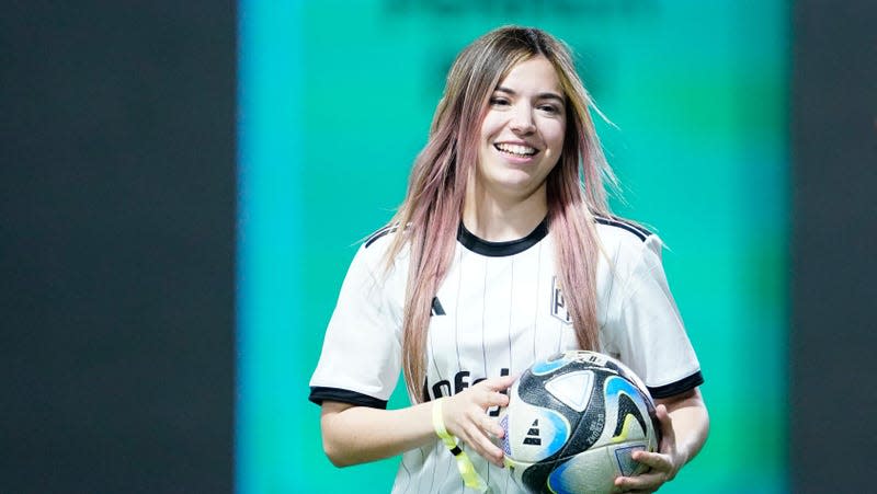 Rivers is shown holding a soccer ball at the Kings League stadium.