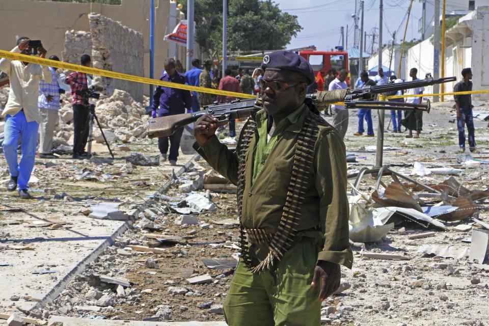 A Somali soldier patrols the area of a suicide car bomb attack in Mogadishu, Somalia, Monday, Jan. 2, 2017. A suicide bomber detonated an explosives-laden vehicle at a security checkpoint near Mogadishu's international airport Monday, killing at least three people, a Somali police officer said. (AP Photo/Farah Abdi Warsameh)