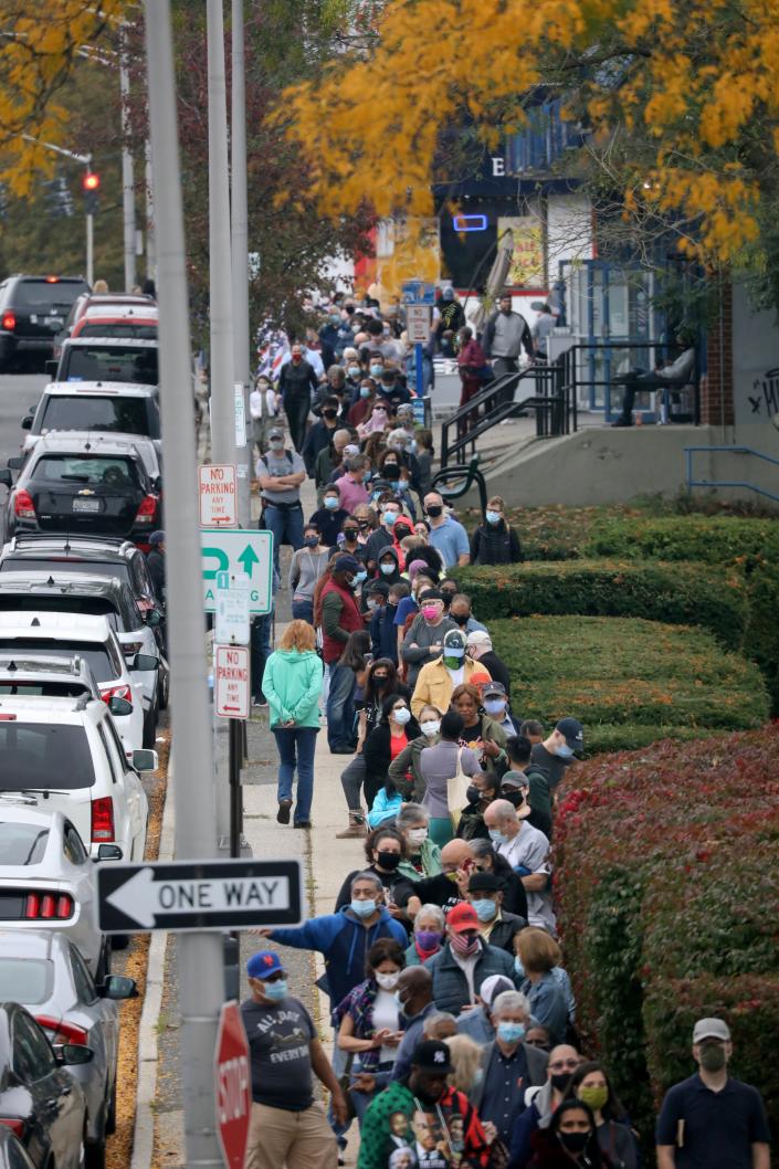 Voters line up in front of the Yonkers Public Library, Grinton I. Will Branch on Central Park Avenue, as the first day of early voting begins, Oct. 24, 2020. 