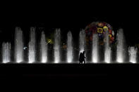 People walk in the empty center of Lyon, central France, Saturday, Oct. 17, 2020. France is deploying 12,000 police officers to enforce a new curfew that came into effect Friday night for the next month to slow the virus spread, and will spend another 1 billion euros to help businesses hit by the new restrictions. (AP Photo/Laurent Cipriani)