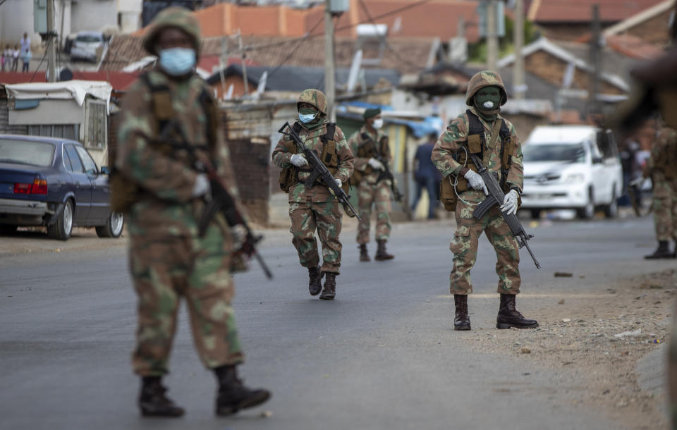 South African National Defence Forces patrol the streets at a densely populated Alexandra township east of Johannesburg, South Africa, Saturday, March 28, 2020. South Africa went into a nationwide lockdown for 21 days in an effort to mitigate the spread to the coronavirus. The new coronavirus causes mild or moderate symptoms for most people, but for some, especially older adults and people with existing health problems, it can cause more severe illness or death. (AP Photo/Themba Hadebe)