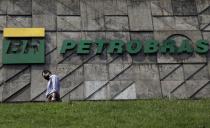 FILE PHOTO: A man walks past the headquarters of Brazilian oil company Petrobras in Rio de Janeiro