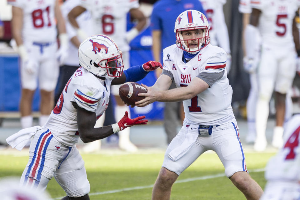 SMU quarterback Shane Buechele (7) hands off to running back Ulysses Bentley IV (26) during the second half of an NCAA college football game against Temple, Saturday, Nov. 7, 2020, in Philadelphia. SMU won 47-23. (AP Photo/Laurence Kesterson)