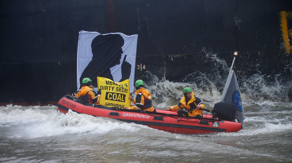 <p>Greenpeace activists ride along a banner with a silhouette of German Chancellor Angela Merkel onto the Golden Opportunity ship carrying coal as part of protests ahead of the upcoming G20 summit, in Hamburg Harbour, Germany July 2, 2017. (Hannibal Hanschke/Reuters) </p>