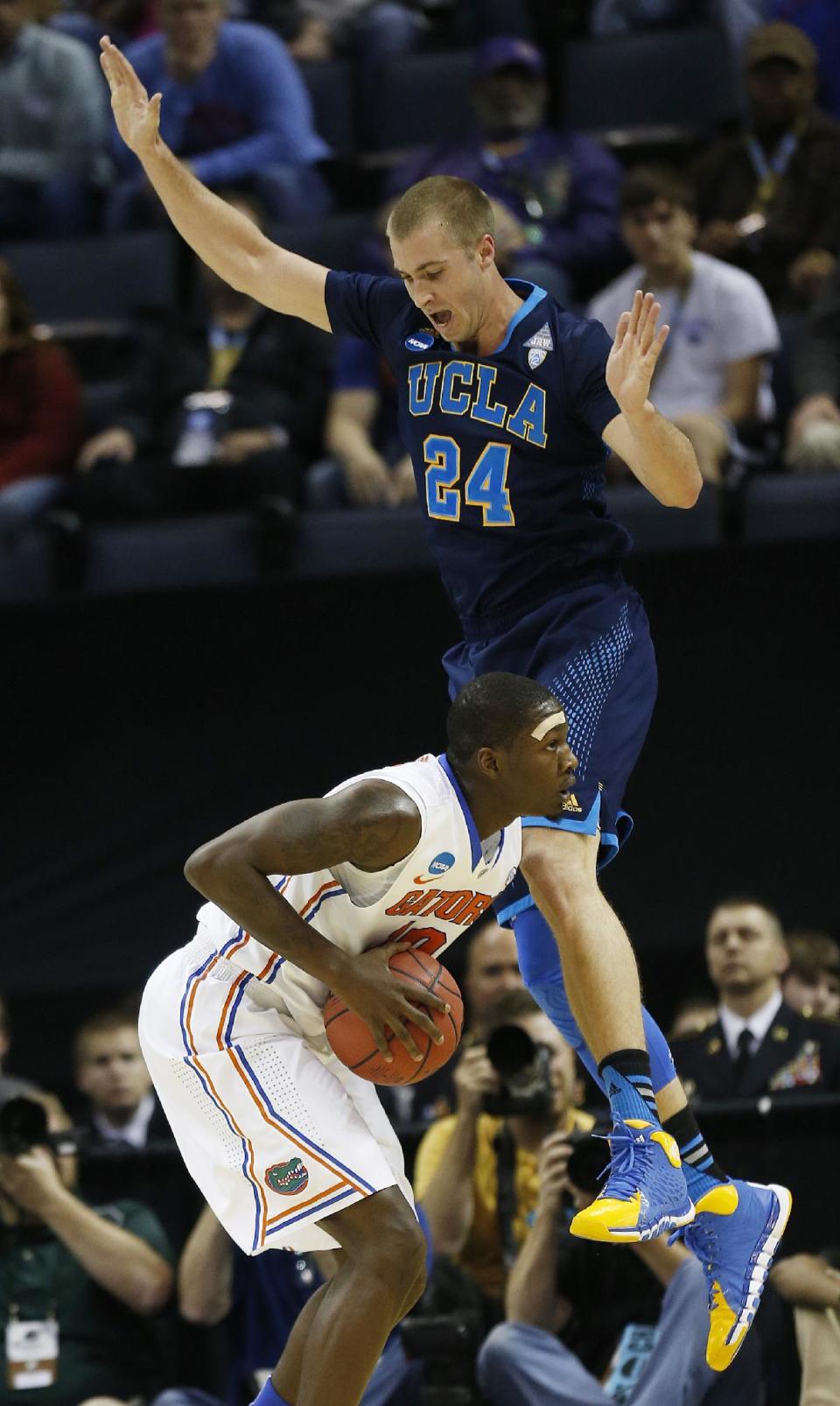 UCLA forward Travis Wear (24) defends Florida forward Dorian Finney-Smith (10) during the first half in a regional semifinal game at the NCAA college basketball tournament, Thursday, March 27, 2014, in Memphis, Tenn. (AP Photo/John Bazemore)