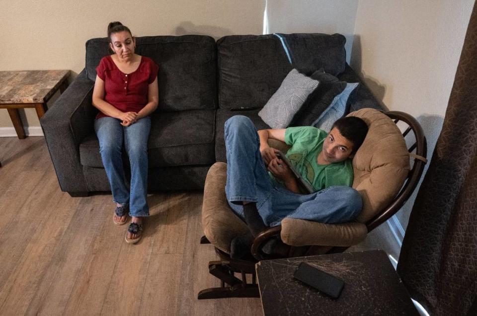 Ana Soto sentada con su hijo Max Morán Soto, de 14 años, autista y con TDAH, el jueves 24 de agosto, en su casa de Manteca.