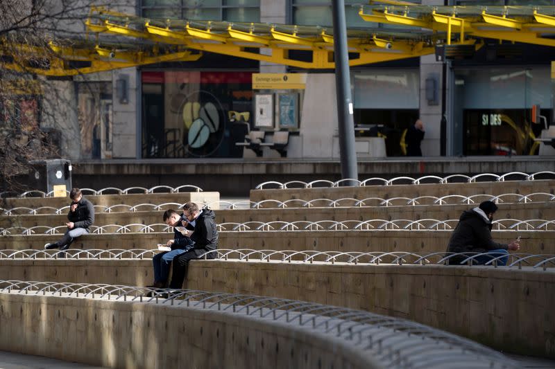 Few members of the public are seen near midday in an extremely quiet central Manchester