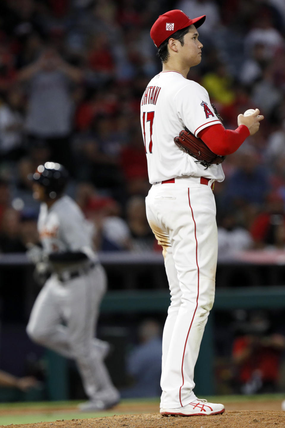 Los Angeles Angels staring pitcher Shohei Ohtani waits Detroit Tigers' Jonathan Schoop rounds third after hitting a solo home run during the sixth inning of a baseball game in Anaheim, Calif., Thursday, June 17, 2021. (AP Photo/Alex Gallardo)
