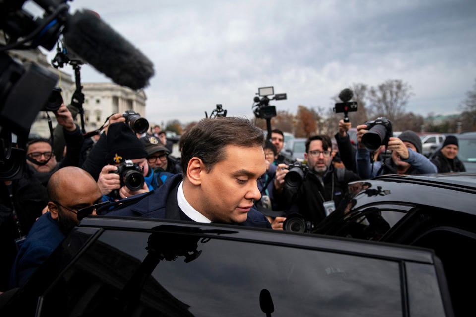 Former Rep. George Santos gets into a car, surrounded by photographers and camera crews. ( Al Drago / Bloomberg via Getty Images)