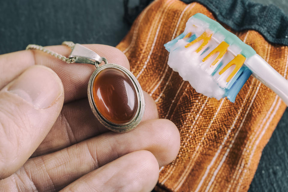 Cleaning silver jewellery with and toothbrush and baking soda