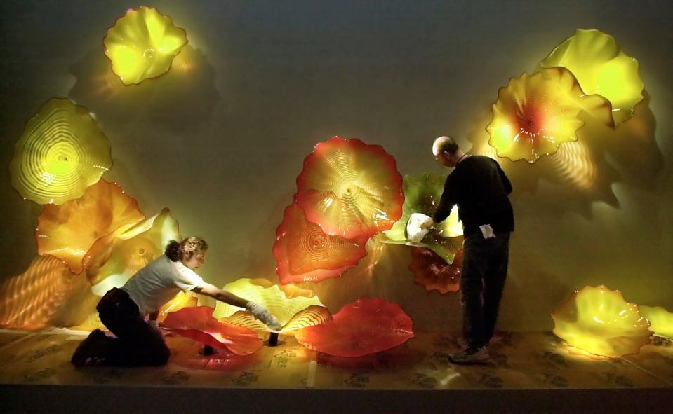 Ernesto Sanchez, left, and Jim Meeks clean colorful artworks in the Dale Chihuly glass art exhibit in the new Oklahoma City Museum of Art on Thursday, March 7, 2002.