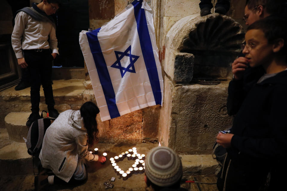 Israeli youth light candles in the shape of the Star of David at the site of a shooting attack that killed an Israeli man in Jerusalem's Old City, Sunday, Nov. 21, 2021. A Hamas militant opened fire in Jerusalem's Old City, killing the 26-year-old Israeli and wounding four other people before he was fatally shot by Israeli police. (AP Photo/Ariel Schalit)