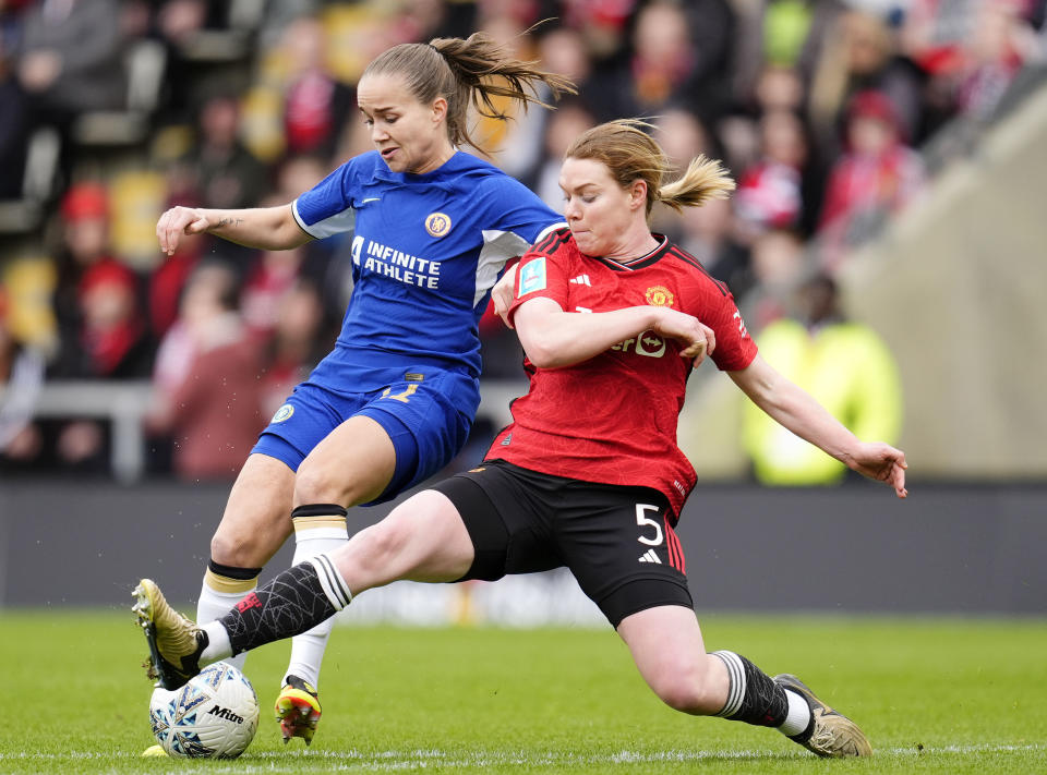Chelsea's Guro Reiten, left, and Manchester United's Aoife Mannion, right, challenge for the ball during the Adobe Women's FA Cup semi-final match between Machester United and Chelsea in Leigh, England, Sunday, April 14, 2024. (Nick Potts/PA via AP)