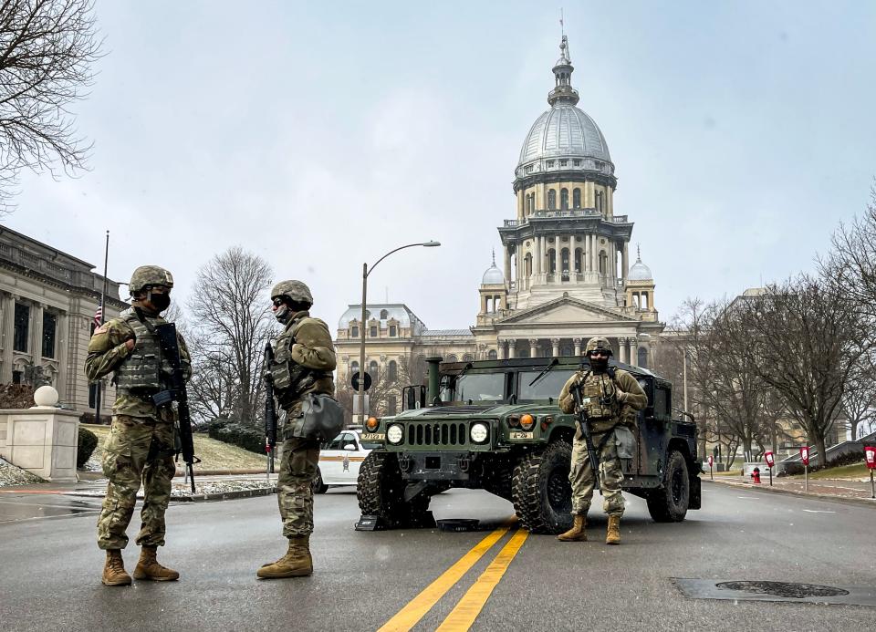 Members of the Illinois National Guard stand posted at a road closure along East Capitol Avenue in front of the Illinois State Capitol on Jan. 17, 2021, in Springfield, Ill.