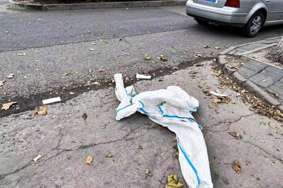 社區內一隻亂丟棄的「大白」防護服躺在地上。