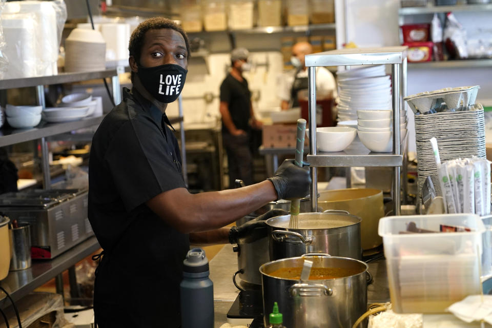 Kinoy Miller prepares food at the Love Life Cafe Thursday, Oct. 29, 2020, in the Wynwood neighborhood of Miami. Florida voters decide Tuesday whether to raise the state's minimum wage to $15 an hour over six years, which advocates say will benefit hundreds of thousands of workers in the Sunshine State's service-heavy economy but which opponents say will stifle industry growth. (AP Photo/Lynne Sladky)