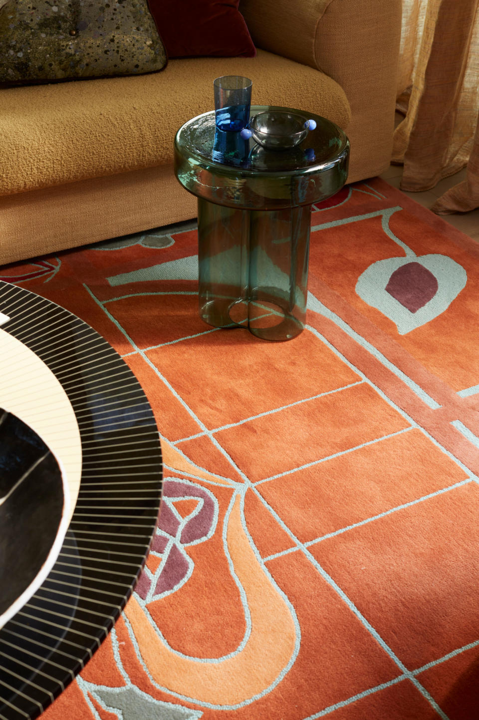 Close-up of orange-hued rug with graphic lines of pale blue