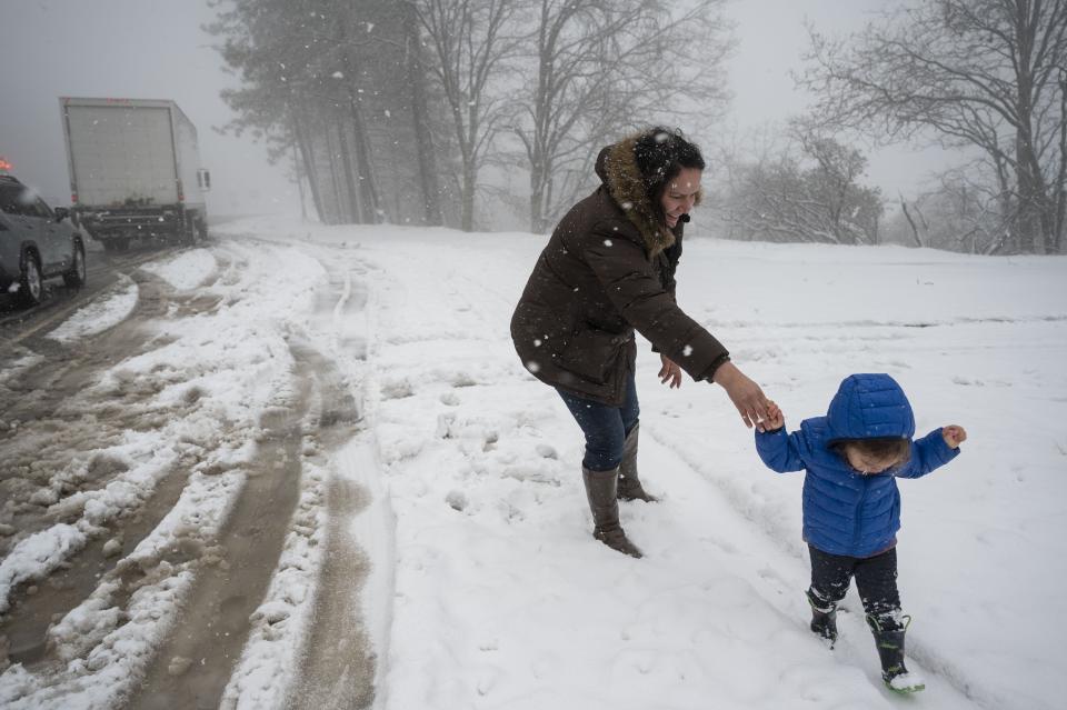 Adirana Chacon, of Walnut Creek, walks with her daughter Alicia, 2, to see the snow for the first time after stopping to put chains on their vehicle on U.S. 50 near Pollock Pines, Calif., Saturday, March 2, 2024. Chain control was in effect from Pollack Pines to Echo Summit after a blizzard brought heavy snow to the Sierra Nevada. (Lezlie Sterling/The Sacramento Bee via AP)