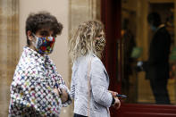 People wearing sanitary masks walk in Via Condotti shopping street, in Rome, Italy, Monday, May 18, 2020. Italy is slowly lifting sanitary restrictions after a two-month coronavirus lockdown. (Cecilia Fabiano/LaPresse via AP)