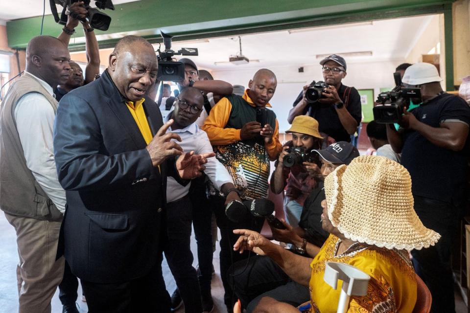 South African President Cyril Ramaphosa speaks to an ANC supporter during the nationwide voter registration campaign ahead of the 2024 election (AFP via Getty Images)