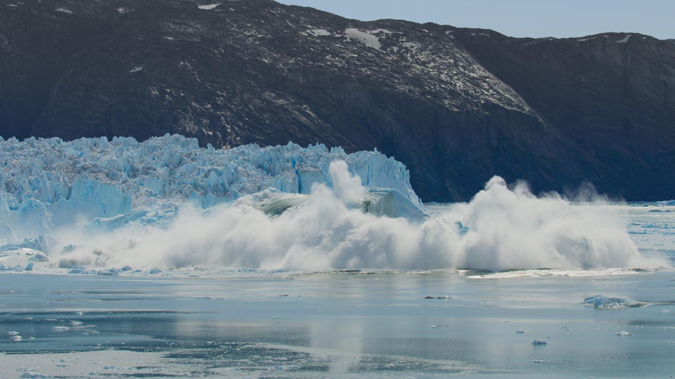 A section of glacier breaks off into the sea surrounding Greenland. (BBC)