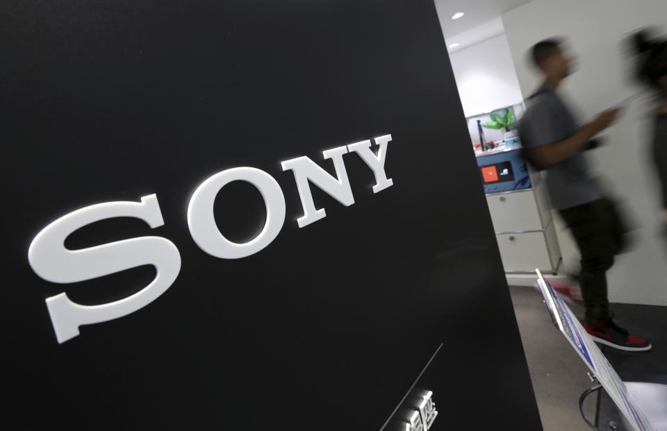 FILE - In this July 31, 2014, file photo, visitors walk past a logo of Sony at Sony Building in Tokyo. Japanese electronics and entertainment company Sony Corp. reported Wednesday that its quarterly profit tumbled as the coronavirus pandemic delayed music and movie releases and disrupted product supply chains. (AP Photo/Eugene Hoshiko, File)