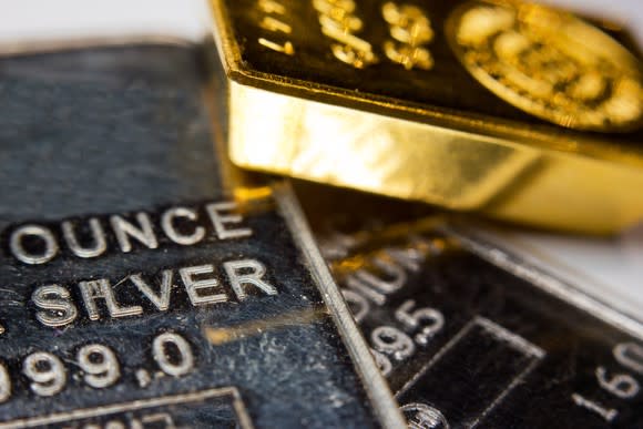 Bullions of gold, silver, and palladium, heaped on a table.