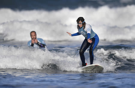 Carmen Lopez Garcia, Spain's first blind female surfer who is to participate in the ISA World Adaptive Surfing Championship, is watched by her coach Lucas Garcia during training at Salinas beach, Spain, December 6, 2018. REUTERS/Eloy Alonso