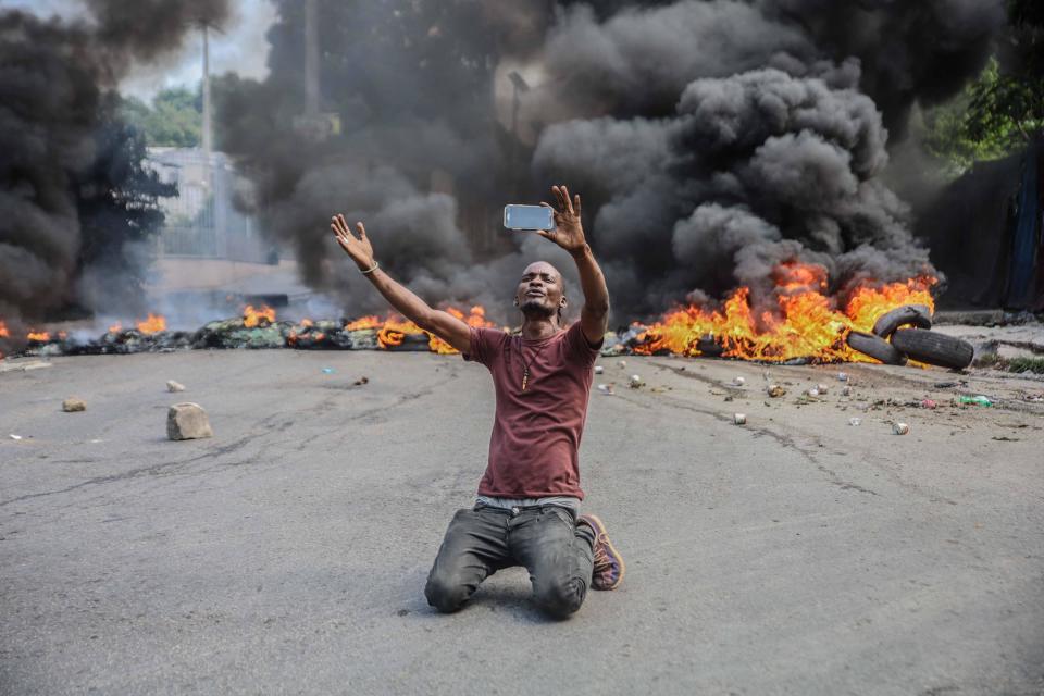 A man is seen in front of burning tires during a general strike launched by several professional associations and companies to denounce insecurity in Port-au-Prince, Haiti, October 18, 2021. / Credit: RICHARD PIERRIN/AFP/Getty